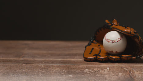 Close-Up-Studio-Baseball-Still-Life-With-Ball-In-Catchers-Mitt-On-Wooden-Floor-1
